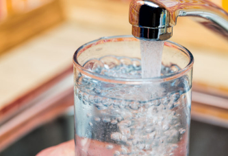 Verre d'eau rempli depuis un robinet